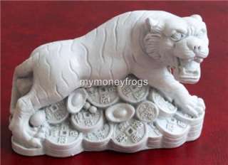 Feng shui tigers standing on Chinese money are a symbol of wealth and 