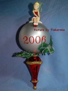 TINKERBELL IN RED SITS ATOP A 2006 SILVER BALL ORNAMENT  