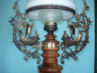 The lamp has a shade of milkglass and has very nice decorated chains.